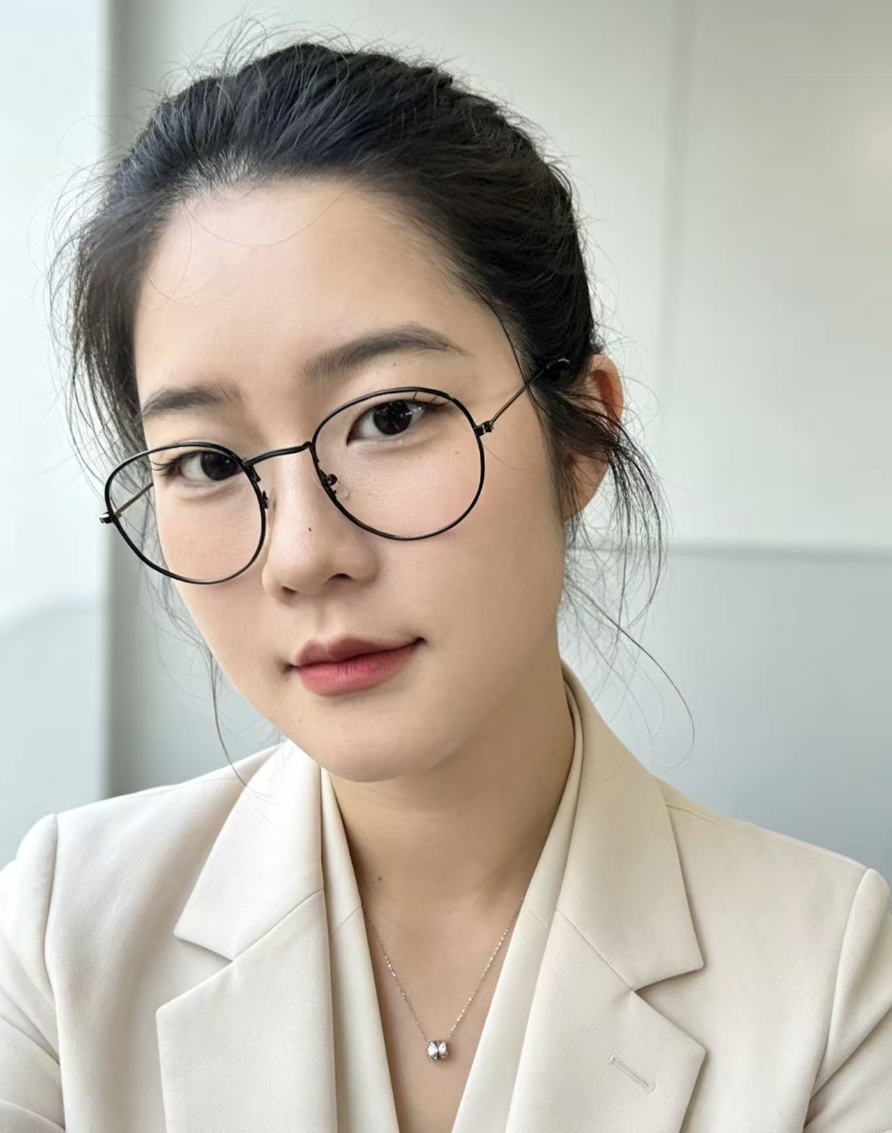 方婷的个人照片,戴着圆框眼镜,身穿米白色西装